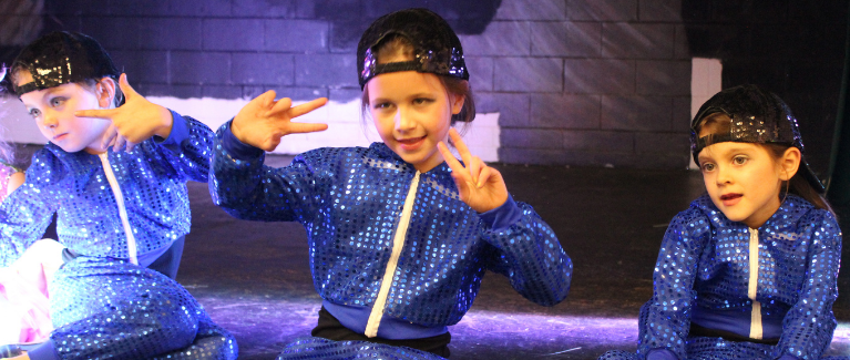 Kids dressed up and performing hip hop